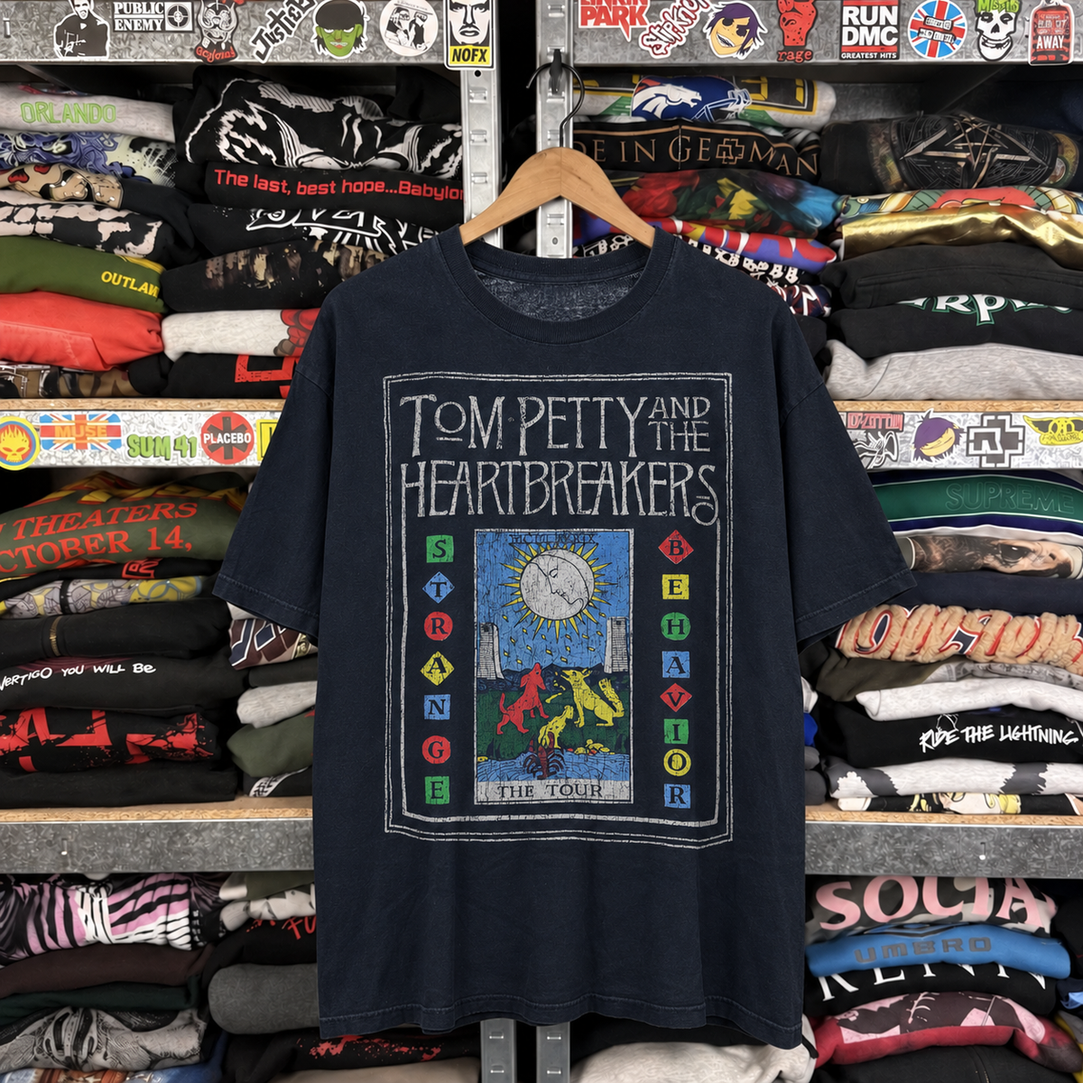 1989 Tom Petty & The Heartbreakers 'Strange Behavior Tour' Washed Black T-Shirt — off-body front on wooden hanger