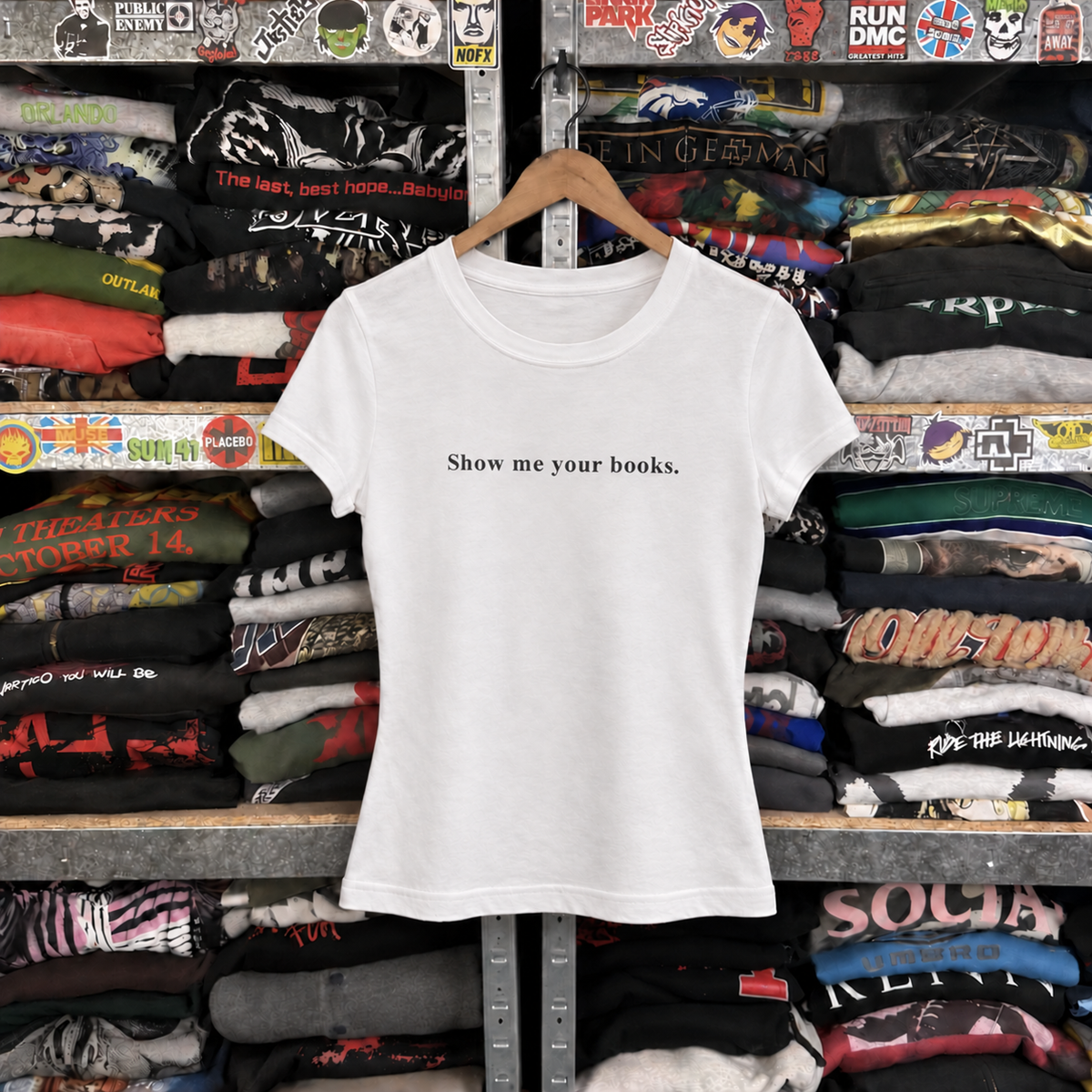 Show Me Your Books White Baby Tee — off-body front on wooden hanger